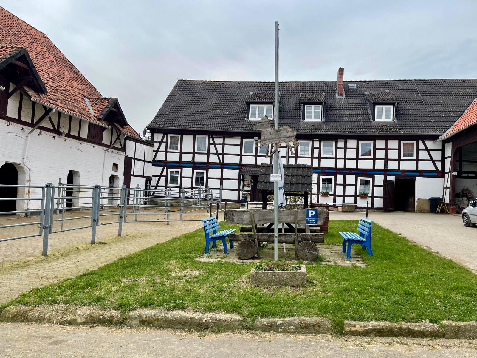 Hofplatz mit historischem Fachwerkgebäude und Dorfbrunnen